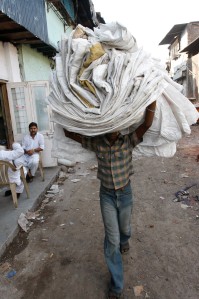 Man carrying recycled bags, Dharavi slum (photo: courtesy of Reality Gives)